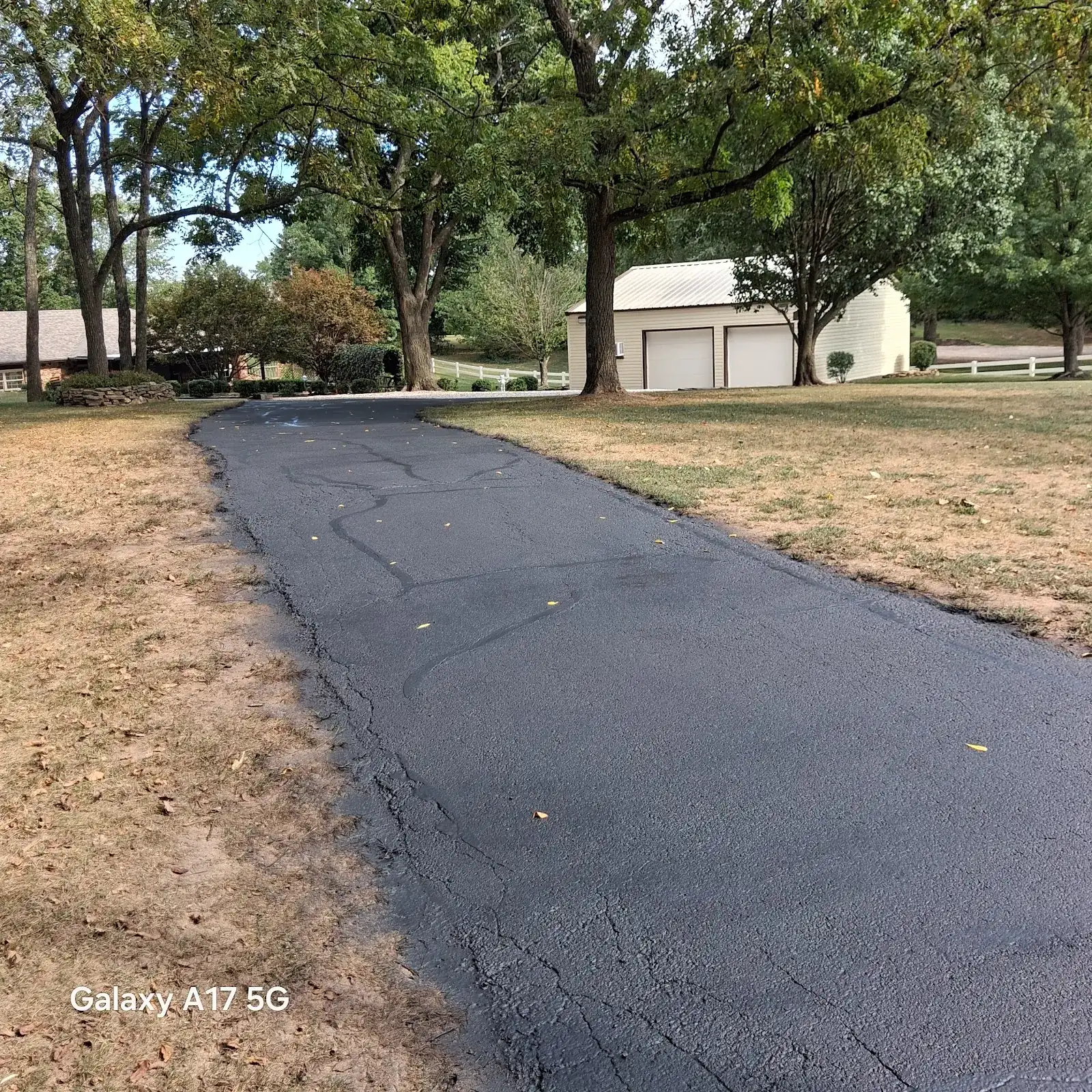 A long residential driveway freshly sealcoated